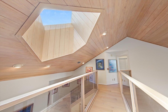 corridor featuring lofted ceiling, wood ceiling, and light hardwood / wood-style flooring