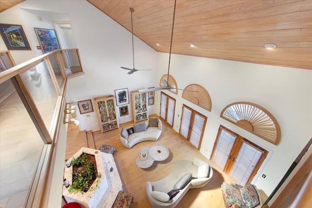 living room featuring high vaulted ceiling, wooden ceiling, and light wood-type flooring