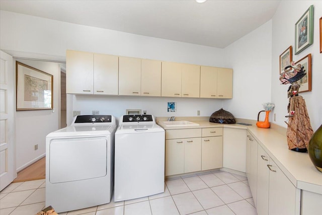 clothes washing area with cabinets, separate washer and dryer, sink, and light tile patterned floors