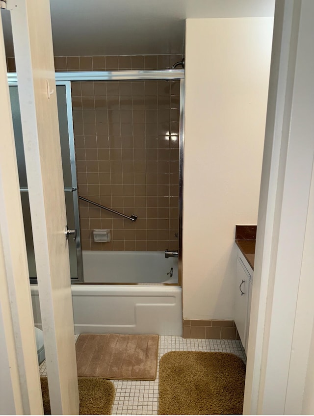 bathroom with tile patterned floors, shower / bath combination with glass door, and vanity