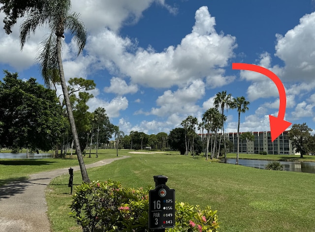 view of property's community with a water view and a lawn