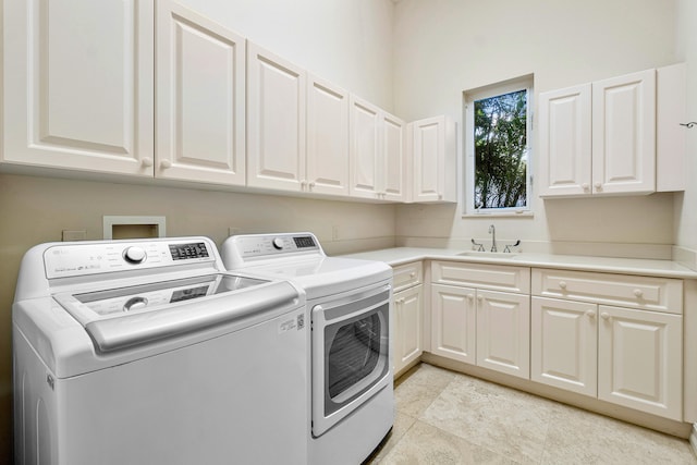 washroom featuring cabinets, sink, and washing machine and clothes dryer