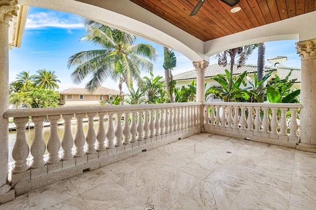 view of patio with ceiling fan and a balcony