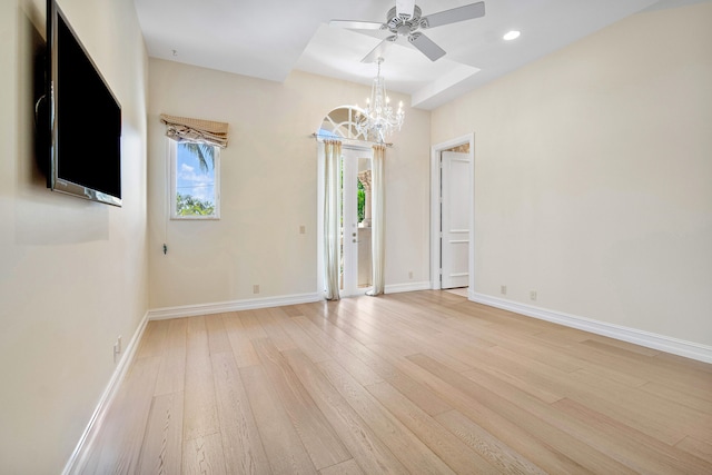 unfurnished room with light hardwood / wood-style flooring and ceiling fan with notable chandelier