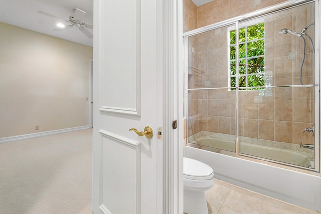 bathroom with tile patterned flooring, ceiling fan, toilet, and bath / shower combo with glass door