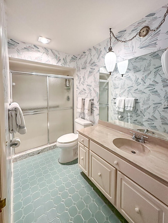 bathroom with vanity, toilet, and a shower with shower door