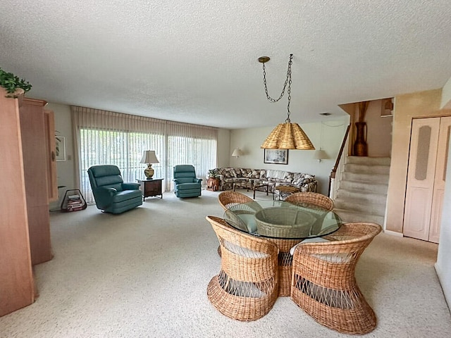 dining area featuring a textured ceiling and light carpet