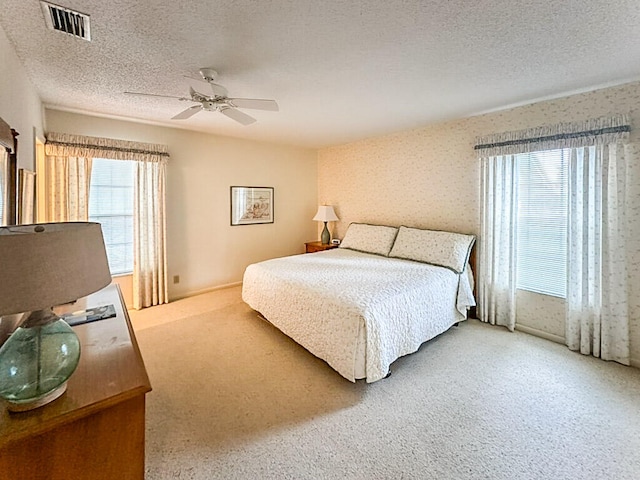 bedroom with carpet, ceiling fan, and a textured ceiling