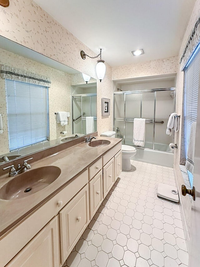 full bathroom with vanity, combined bath / shower with glass door, and toilet