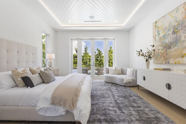 bedroom featuring wood ceiling, multiple windows, and a tray ceiling