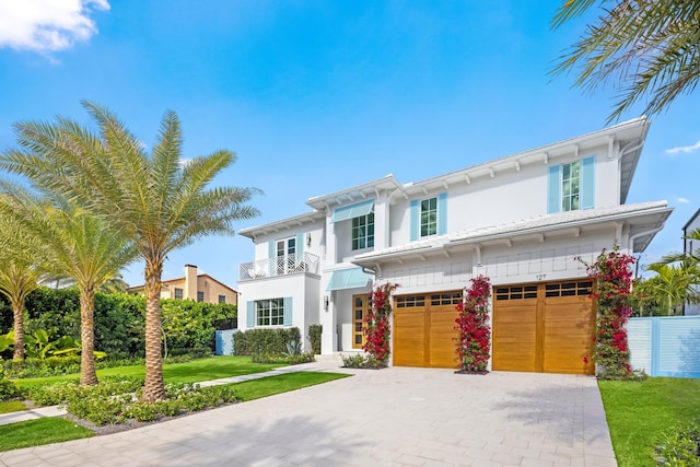 view of front of property with a balcony, a garage, and a front yard