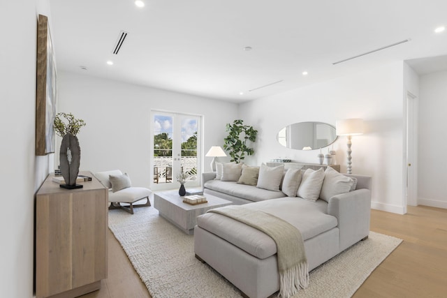 living room with french doors and light hardwood / wood-style flooring