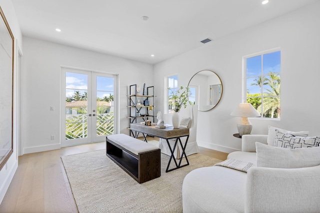 office with light hardwood / wood-style flooring and french doors