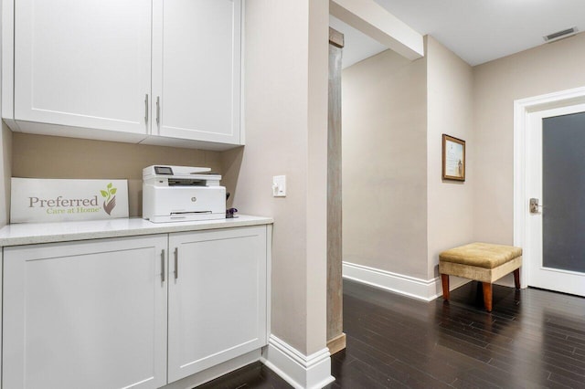 laundry area with dark wood-type flooring