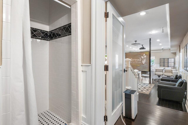 bathroom featuring a tile shower and wood-type flooring