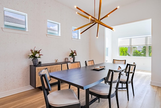 dining room featuring an inviting chandelier, light wood-type flooring, and plenty of natural light