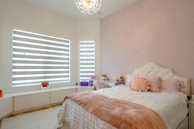 bedroom featuring light wood-type flooring and a chandelier