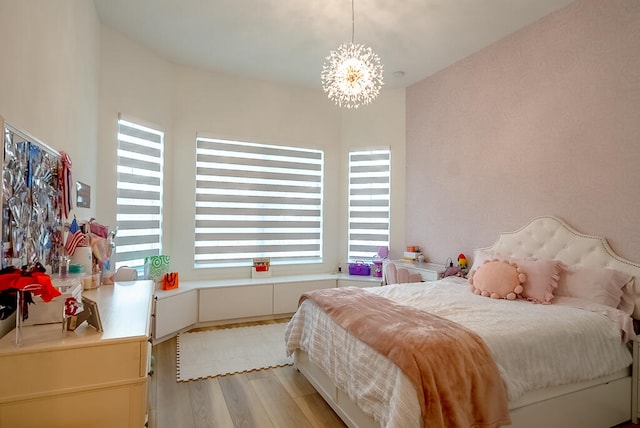 bedroom with light hardwood / wood-style flooring, multiple windows, and an inviting chandelier