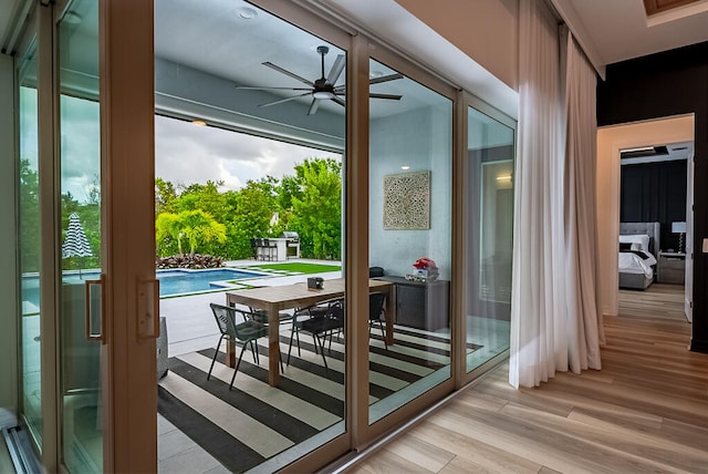 doorway with ceiling fan and light hardwood / wood-style floors