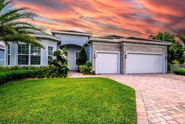 view of front of house with a garage and a yard