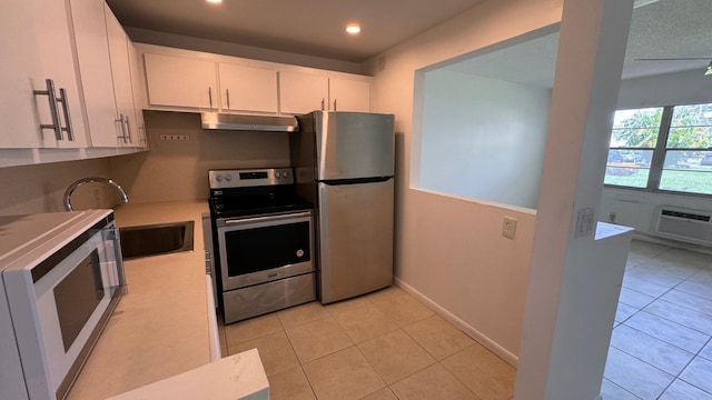 kitchen with sink, appliances with stainless steel finishes, white cabinetry, and light tile patterned flooring