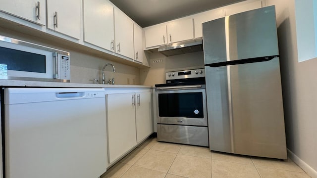 kitchen with stainless steel appliances, sink, light tile patterned floors, and white cabinets