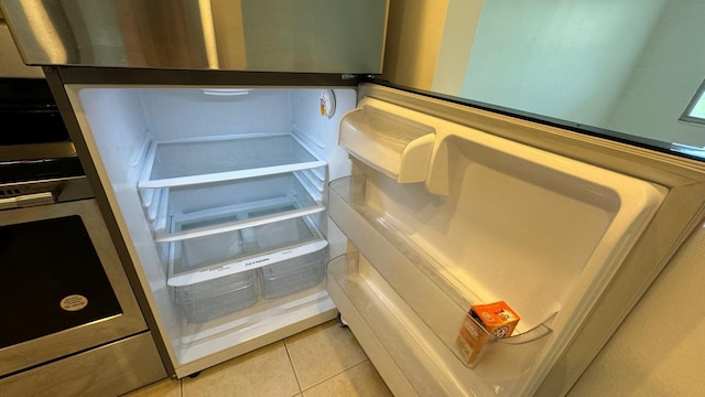 interior details with fridge and light tile patterned flooring