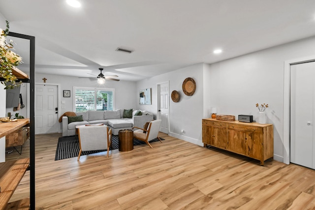 living room with light wood-type flooring and ceiling fan