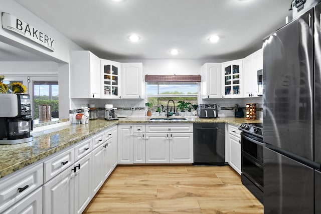 kitchen featuring black appliances, sink, and white cabinets