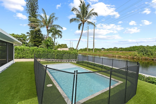 view of swimming pool featuring a lawn and a water view