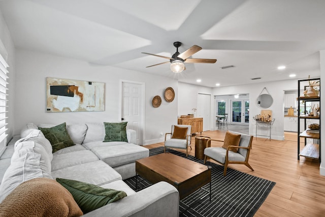 living room featuring light wood-type flooring and ceiling fan