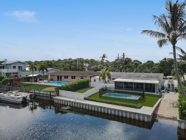 rear view of house featuring a lawn, a water view, and a patio area