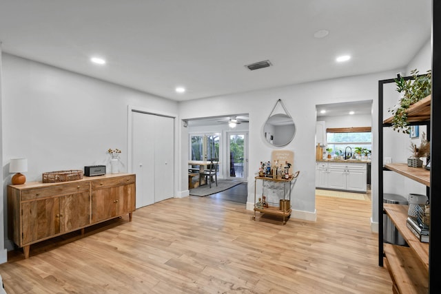 foyer entrance with light hardwood / wood-style floors, sink, and ceiling fan