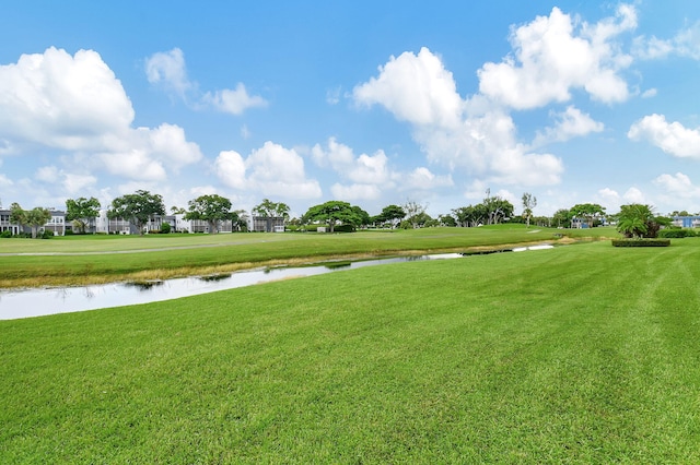 view of home's community with a water view and a yard