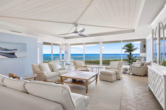 sunroom / solarium with ceiling fan with notable chandelier, a water view, and wooden ceiling