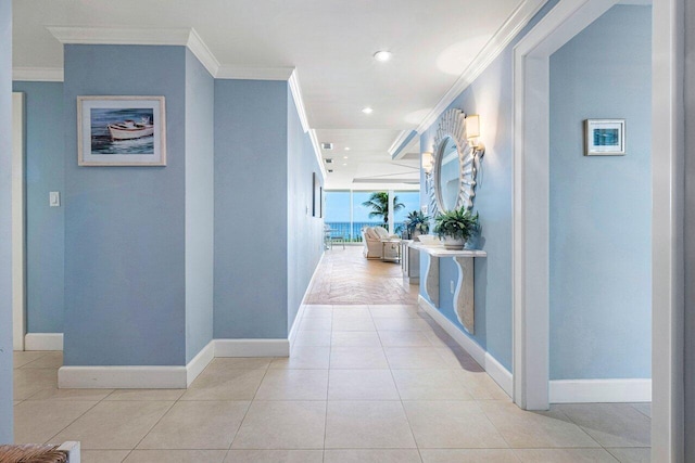 hall featuring crown molding and light tile patterned floors