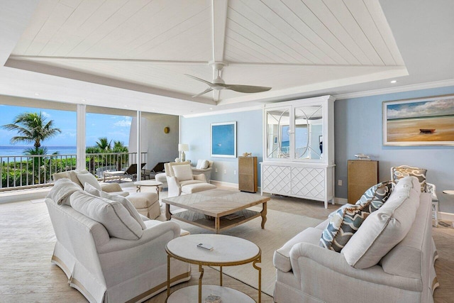 carpeted living room featuring ceiling fan and a raised ceiling