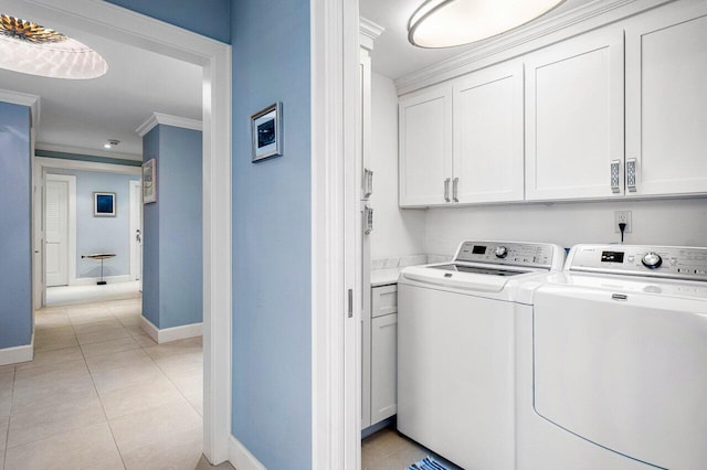 washroom with light tile patterned floors, crown molding, cabinets, and separate washer and dryer