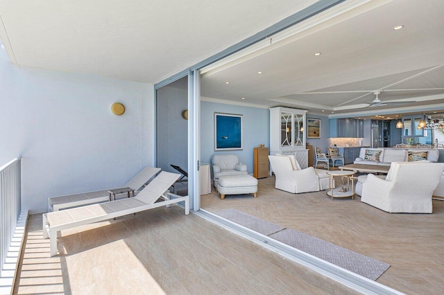 living room with ceiling fan and crown molding