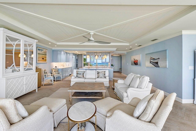 living room with ornamental molding, a raised ceiling, hardwood / wood-style flooring, and ceiling fan