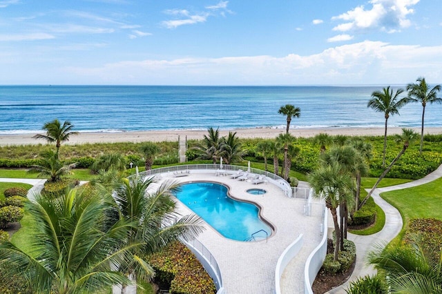 view of swimming pool with a beach view and a water view