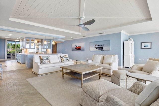 living room featuring crown molding, light parquet flooring, a tray ceiling, and ceiling fan