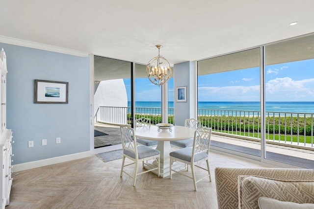 sunroom / solarium featuring a water view, a wealth of natural light, and a notable chandelier