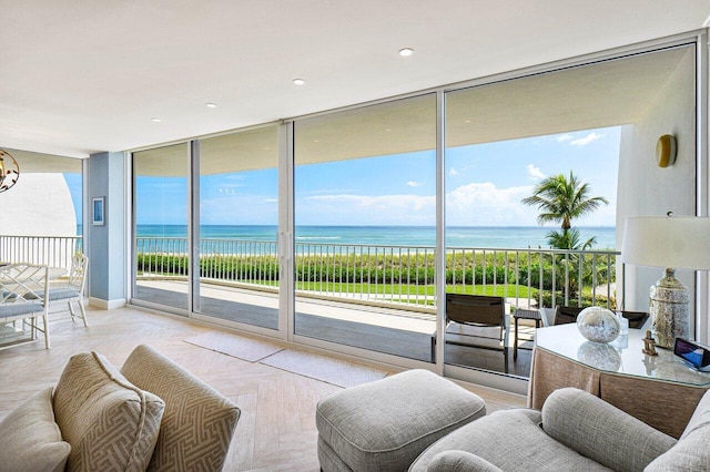 living room featuring light parquet flooring, a water view, and expansive windows