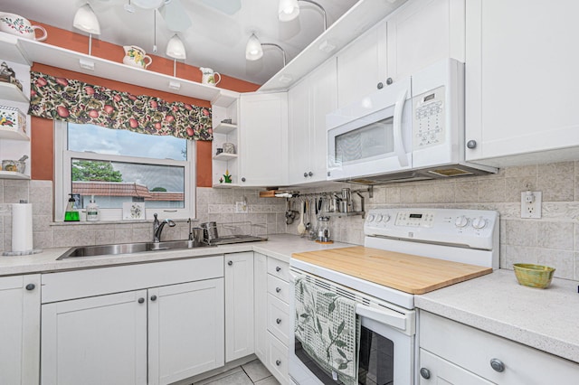 kitchen featuring white appliances, white cabinetry, sink, ceiling fan, and decorative backsplash