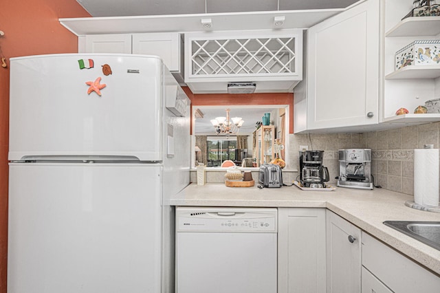 kitchen featuring backsplash, a notable chandelier, white appliances, and white cabinets