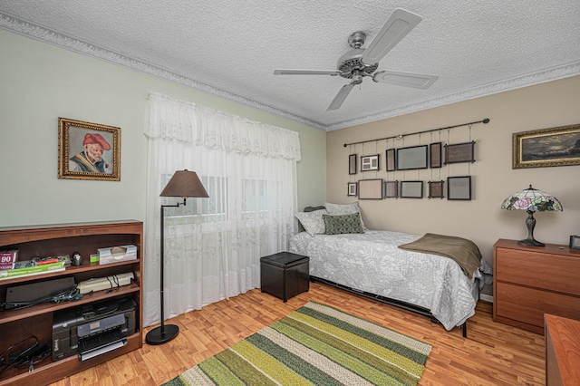 bedroom featuring light wood-type flooring, ceiling fan, and a textured ceiling