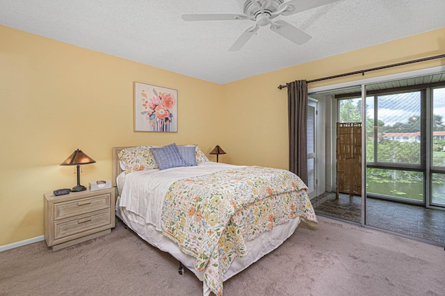 carpeted bedroom featuring a textured ceiling and ceiling fan