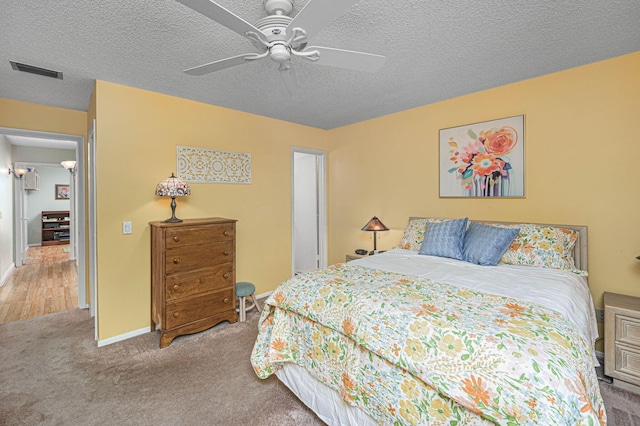 carpeted bedroom with a textured ceiling and ceiling fan