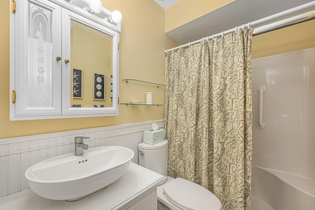 bathroom featuring a shower with shower curtain, toilet, and vanity